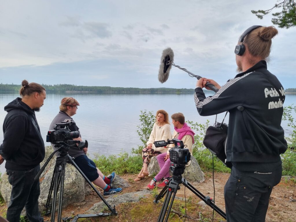 Camera Crew filming people talking by a lake