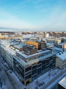 Talvinen kaupunkimaisema, lumisia rakennuksia ja katuja.