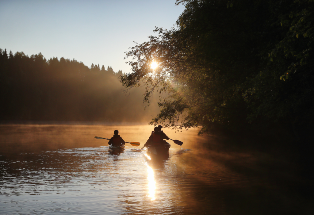 Veneilijät veneessä Oulujokilaaksossa.