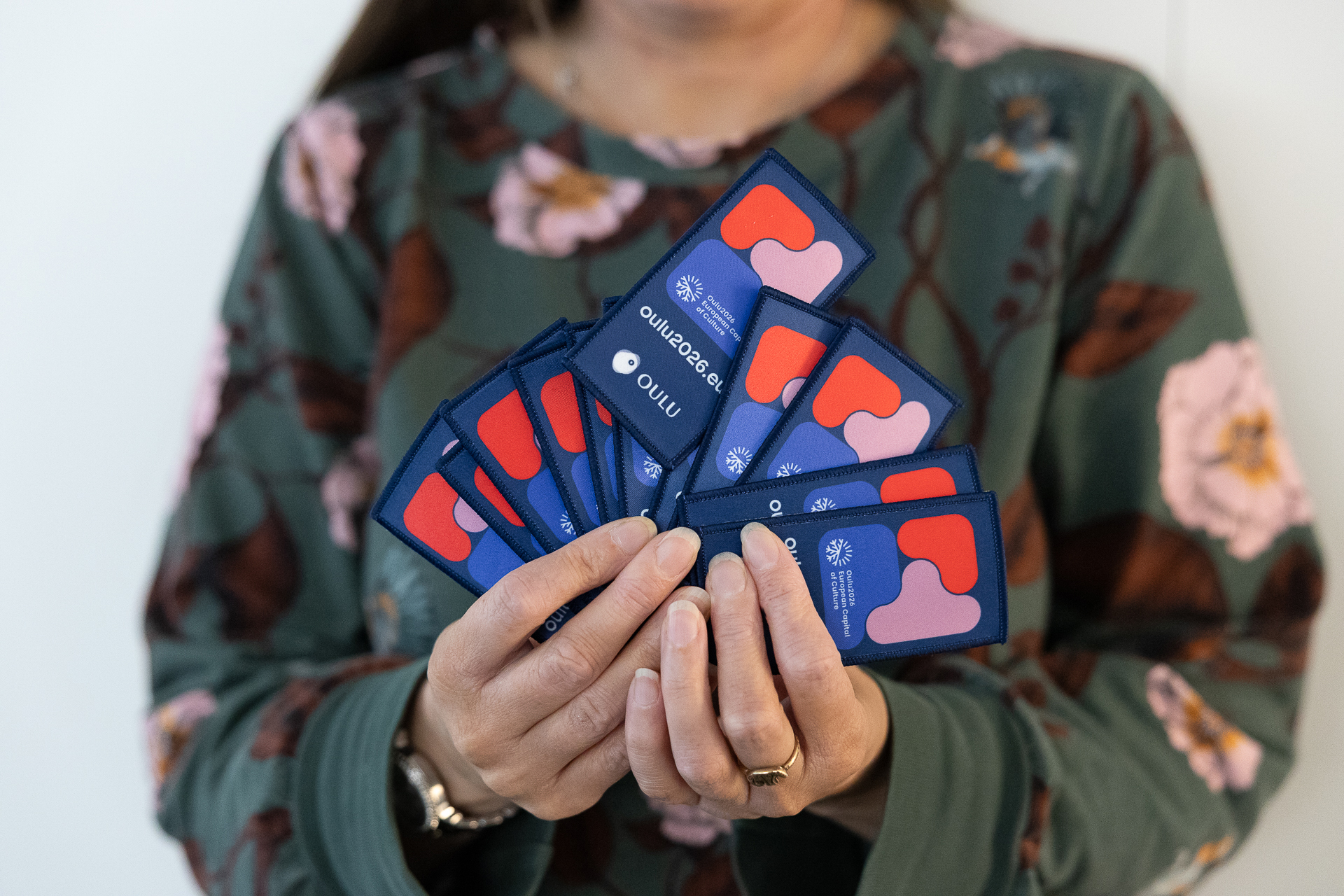 Kädet esittelevät Oulu-tunnisteita.