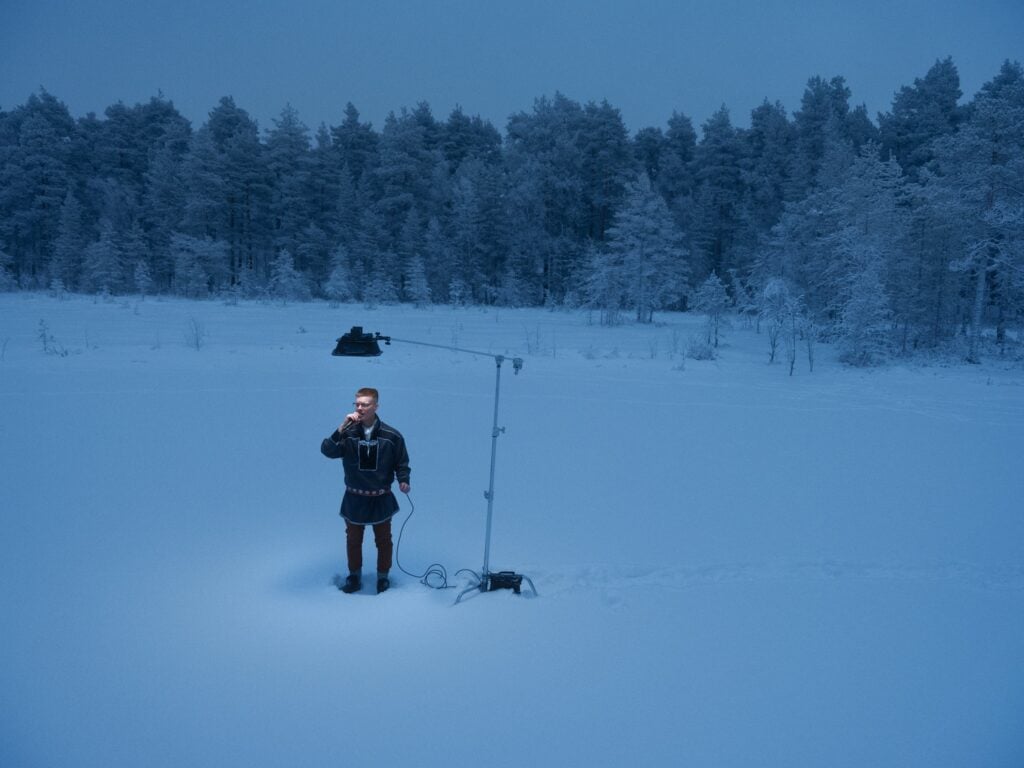 Man i snölandskap med mikrofon och lampa