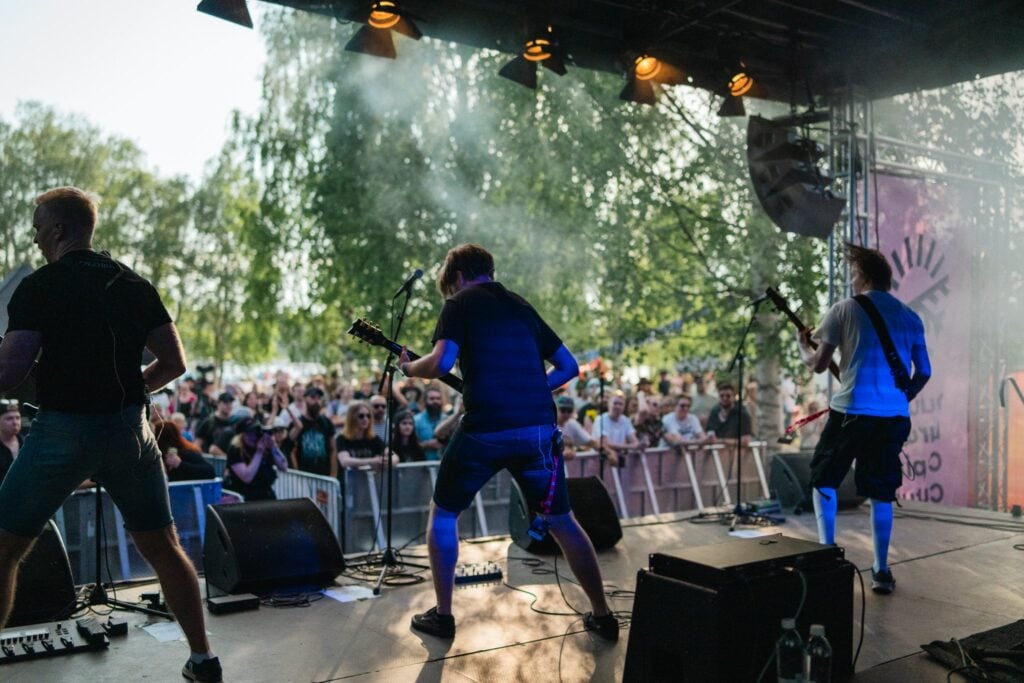 kuvassa ihmisiä ja bändi kesäfestareilla
